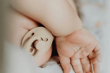 Soft neutral baby clothes hanging on a rack designed for sensitive skin and breathable everyday wear