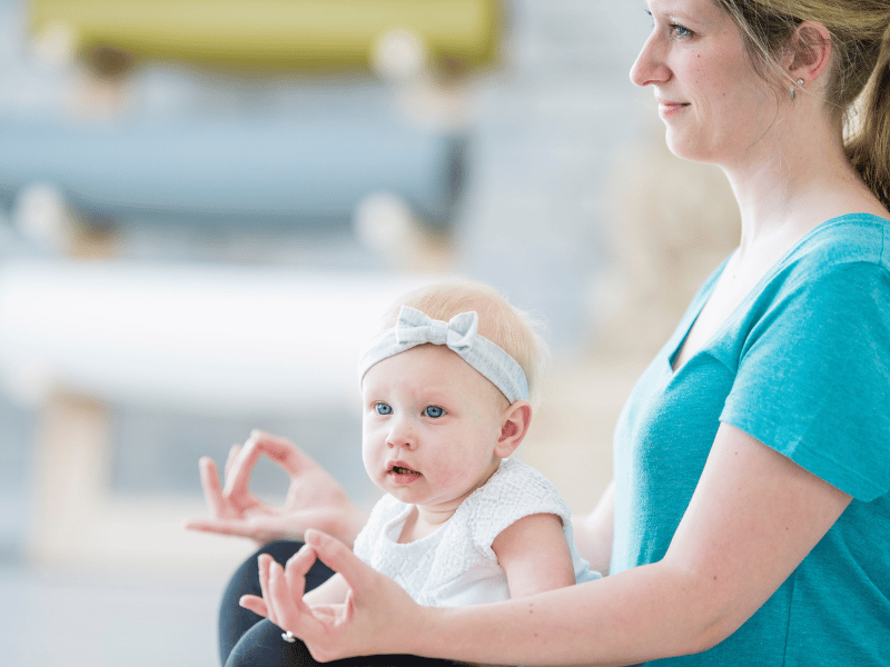 Mother engaging in a gentle yoga session with her baby, enhancing emotional connection through mindful exercises.