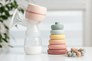Neutral baby feeding items showing silicone bottle and stacking toy used for safe reheating and everyday baby care