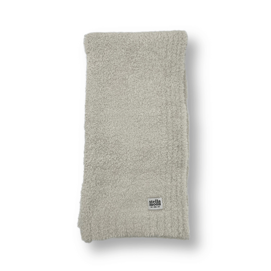 Luxe baby blanket in a soft ice gray color, folded neatly to showcase its plush texture, with a Stella Moon Co. logo tag for added elegance.