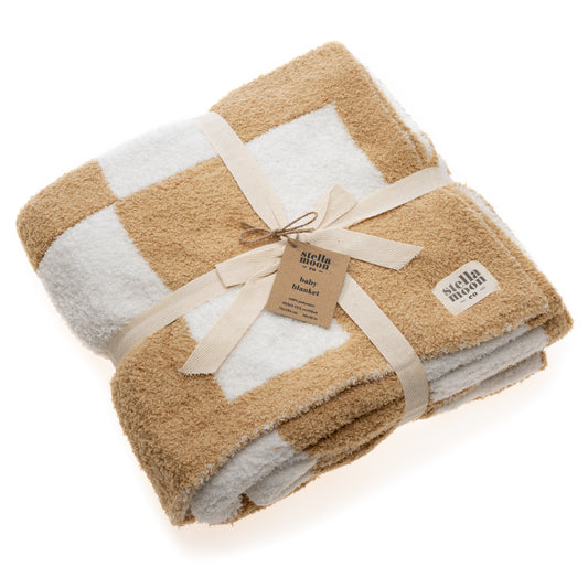 StellaMoon's Luxe Checkered Baby Blanket in Sand laid out, highlighting the intricate checkered design in a neutral sand hue. The soft, plush texture of the 100% polyester fabric is evident, promising coziness for babies of all ages. The OEKO-TEX Standard 100 certification reassures its safety standards. Ideal for nursery decoration or snug moments.