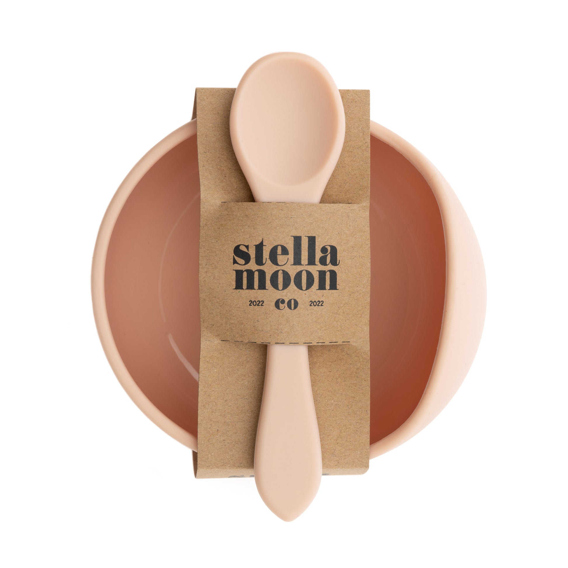 Side angle view of StellaMoon Silicone Suction Bowl and Spoon Set in Nude, highlighting the bowl's depth and the ergonomic design of the accompanying spoon.